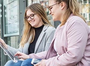 Bürgerinnen und Bürger profitieren an einer Bushaltestelle vom schnelleren Mobilfunkausbau in Münster